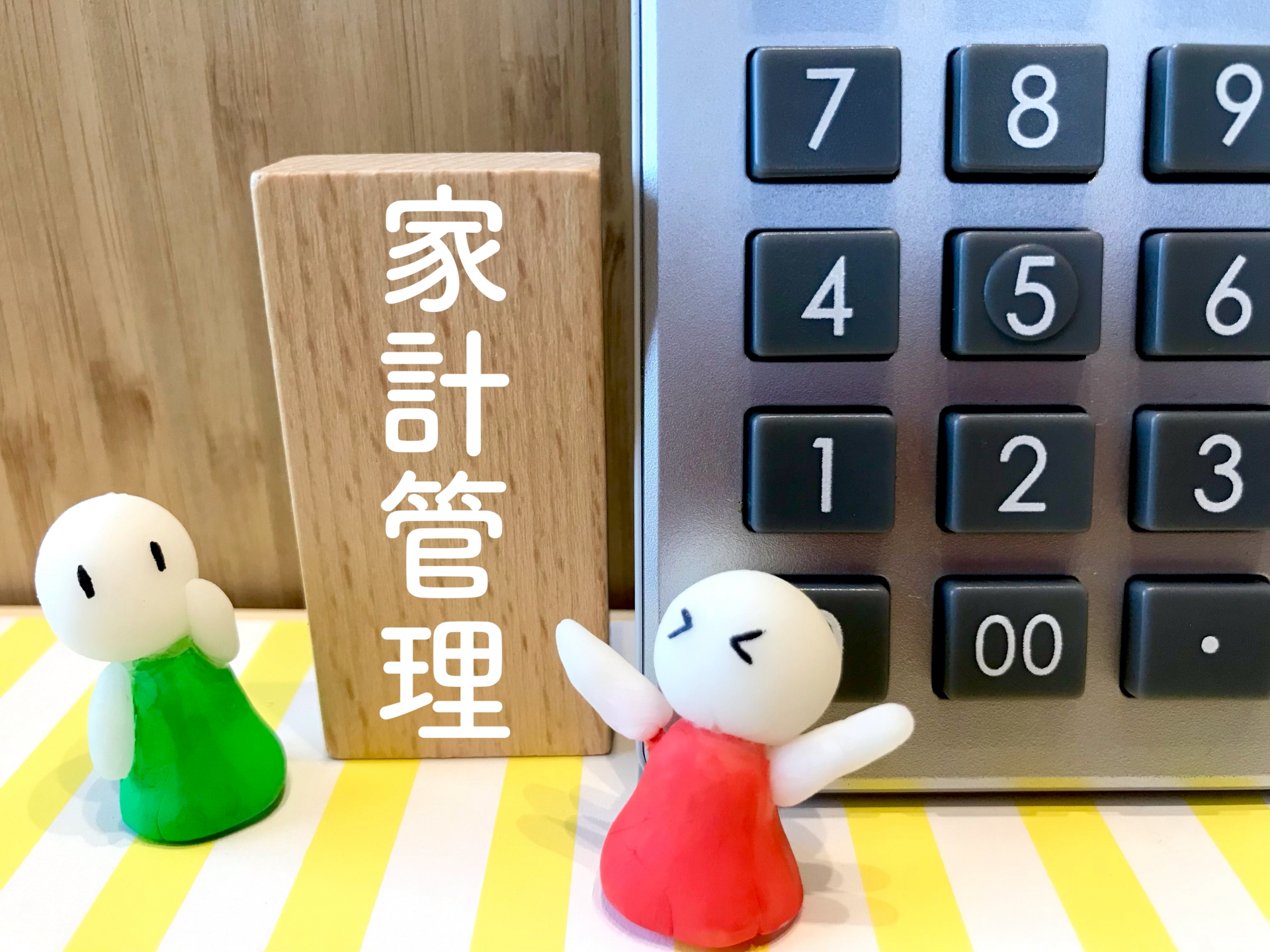「家計管理」の文字と人形、電卓